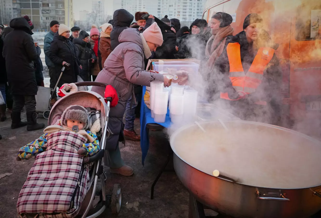 Julia Dolotova (37) får utdelt varm mat i Kyiv i begynnelsen av februar. Mange har ikke mulighet til å lage varm mat hjemme som følge av at de verken har strøm eller varmt vann. Foto: Sergej Grits / AP / NTB