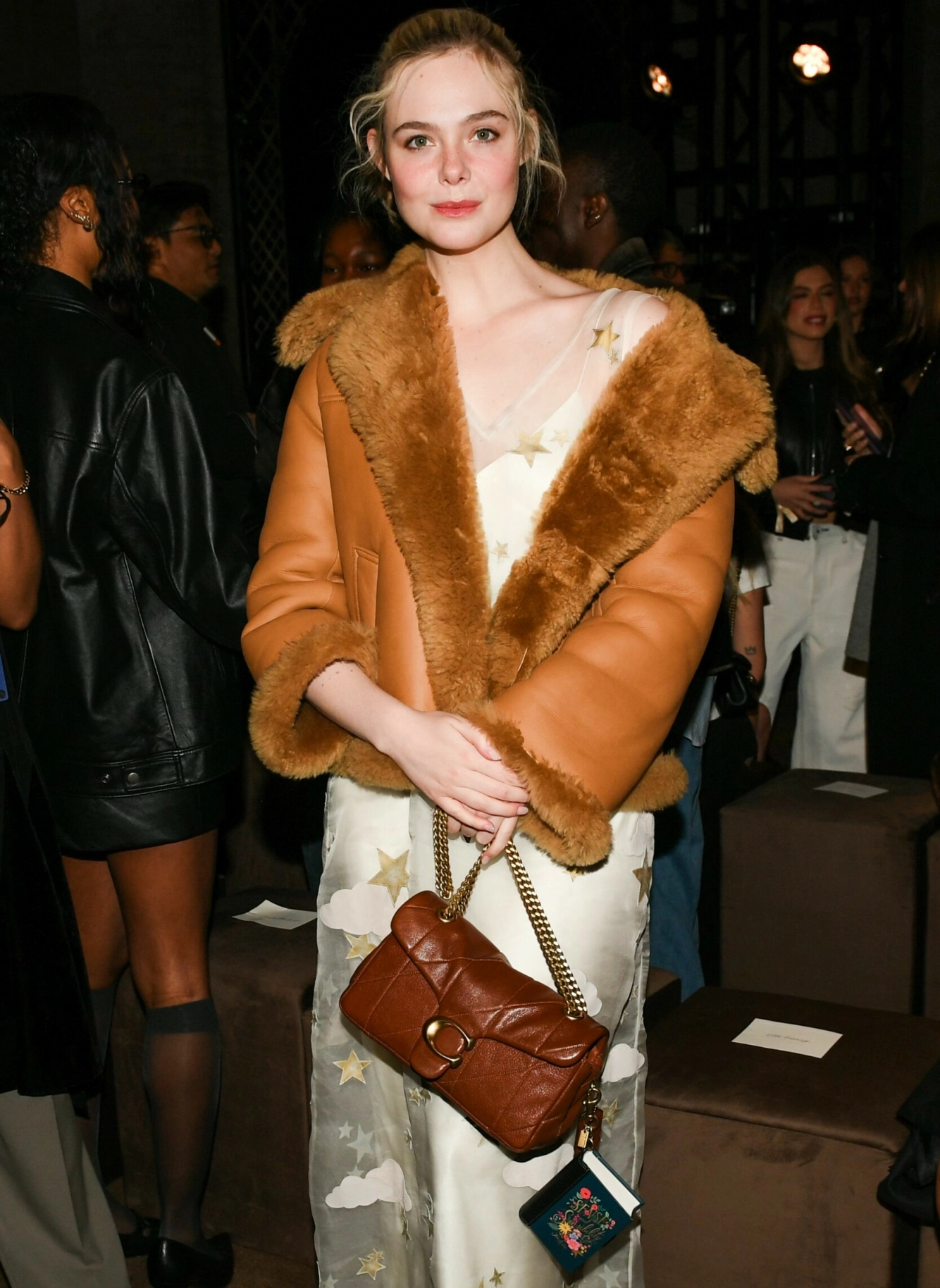 Elle Fanning fronter kampanjen til Coach og ble fotografert med miniboka hengende fra vesken på Coach Fall 2026 Runway Show i New York. Foto: NTB
