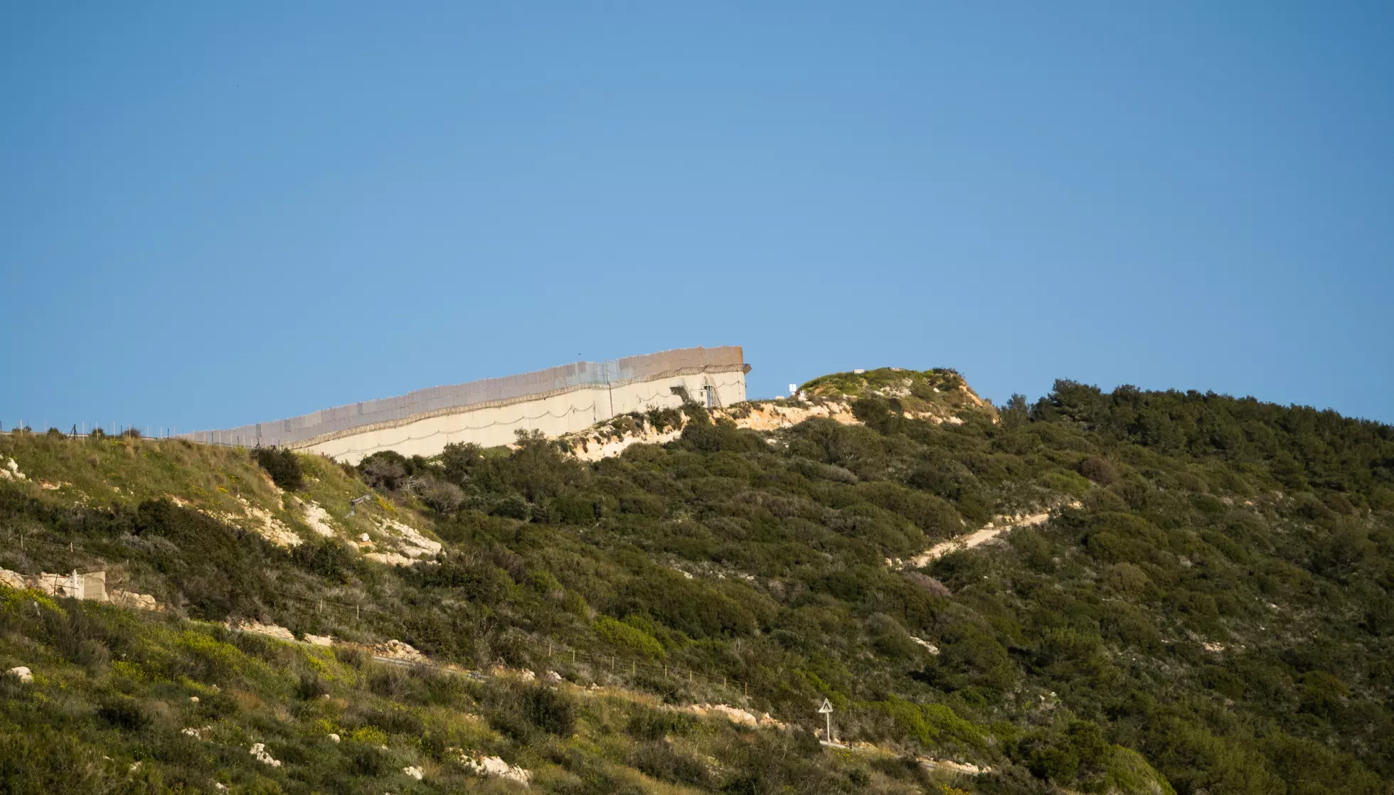 KORT AVSTAND: Bakketoppen over Rosh Hanikra markerer grensen mellom Libanon og Israel. Kibbutzen ligger bare noen hundre meter fra Libanon. Foto: Morten Risberg / Dagbladet