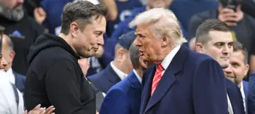 Elon Musk og Donald Trump håndhilser blant publikum under brytemesterskapet i Wells Fargo Center.