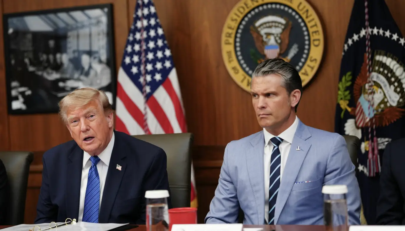 Donald Trump og Pete Hegseth sitter ved et bord under et kabinettmøte på Camp David.