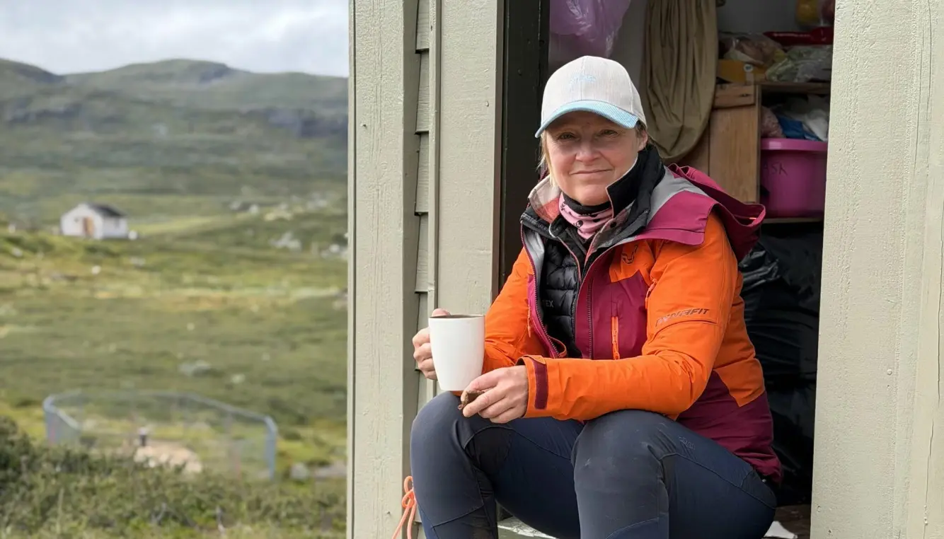 Nysæther som sitter i en liten hytte på marka