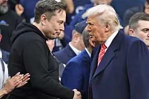 Elon Musk og Donald Trump håndhilser blant publikum under brytemesterskapet i Wells Fargo Center.