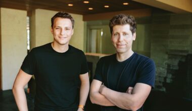 From Phonegram: Two men standing indoors, both wearing black shirts. One has his arms crossed, and the other has his hands at his sides. They are smiling and standing in a modern room.