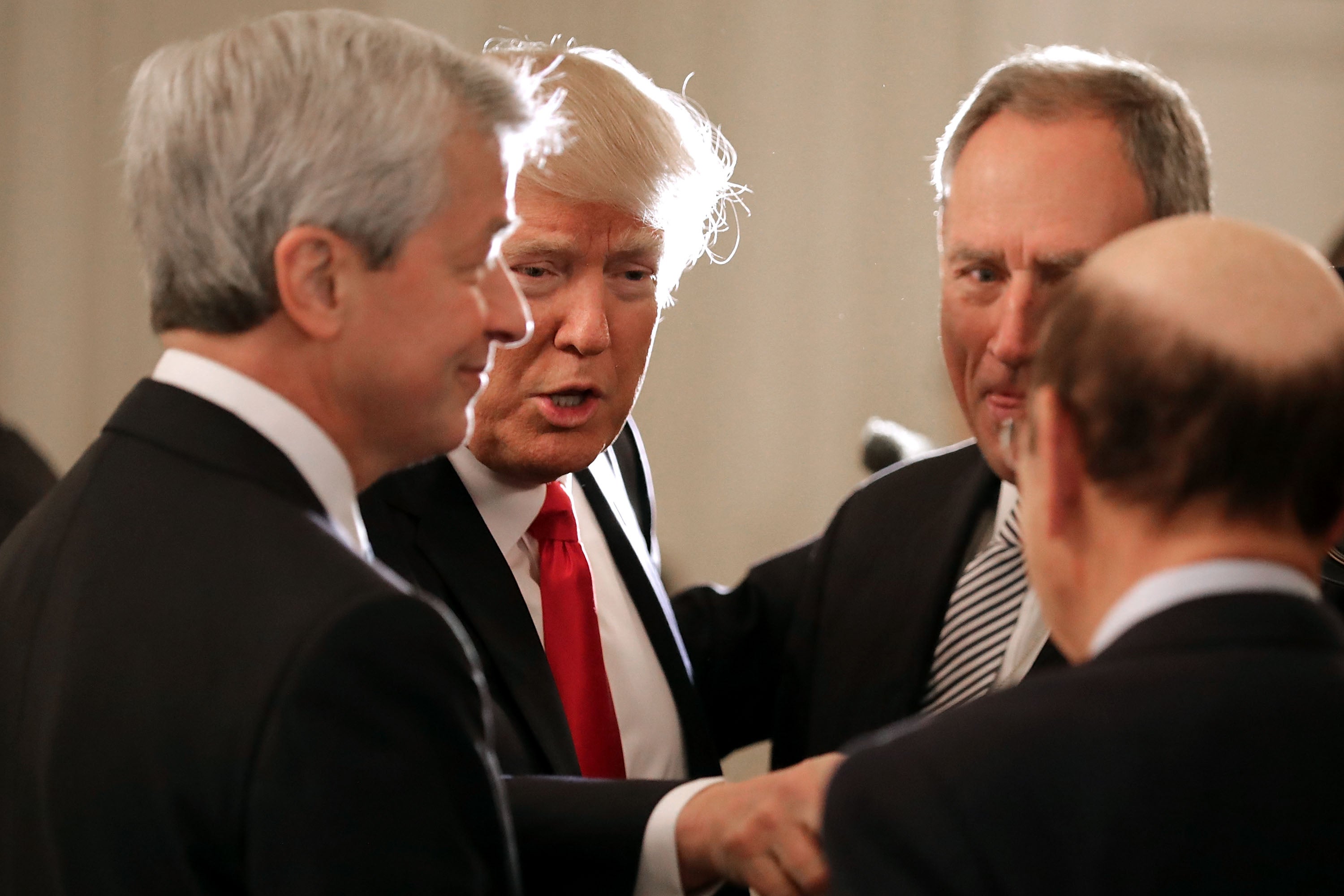 President Donald Trump (2nd L) greets JPMorgan Chase CEO Jamie Dimon (L) and other guests at the beginning of a policy forum in the State Dining Room at the White House February 3, 2017