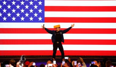 Elon Musk enters the stage wearing a cheesehead during a town hall Sunday, March 30, 2025, in Green Bay, Wis.