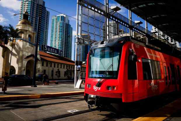 A new state law aims to make it easier to build housing near transit. Pictured: San Diego Trolley loads passengers downtown in mid-September. (Meg McLaughlin / The San Diego Union-Tribune)