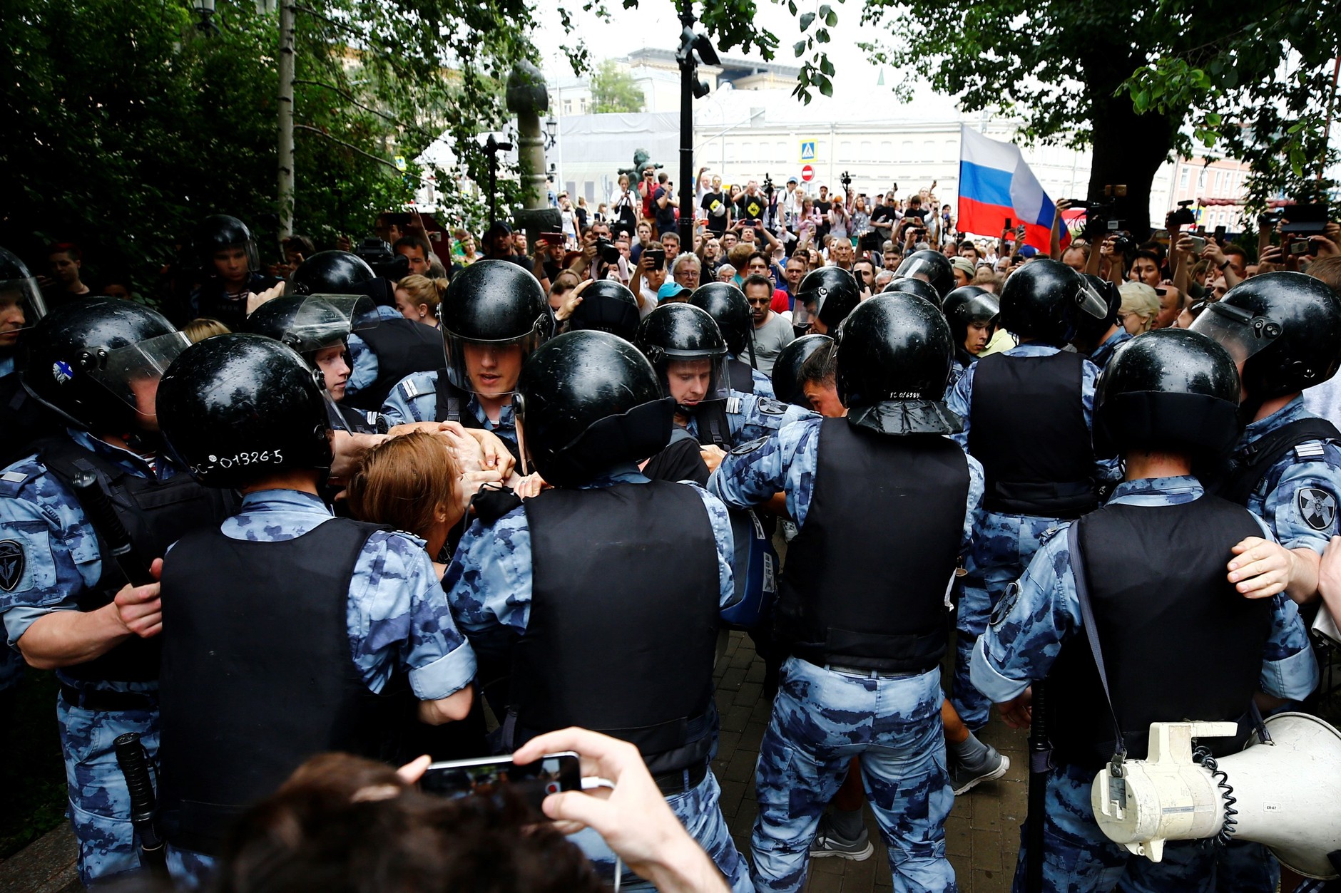 Funkcjonariusze policji zatrzymują kobietę podczas wiecu poparcia dla rosyjskiego dziennikarza Meduzy Iwana Golunowa, 12 czerwca 2019 r