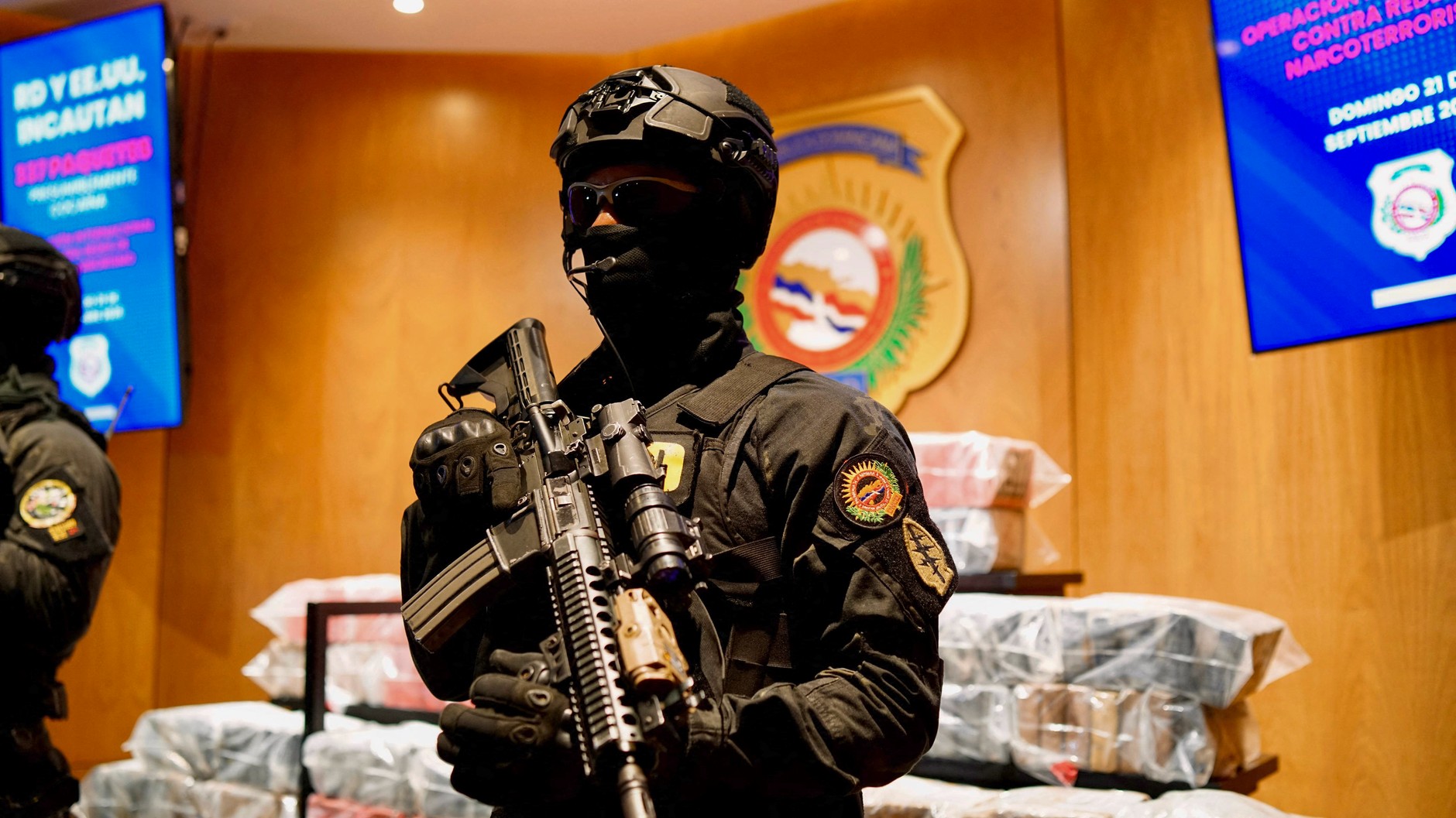 Policjant pilnujący rzekomych paczek kokainy skonfiskowanych podczas amerykańskiej operacji na Karaibach, Santo Domingo, Dominikana, 21 września 2025 r.