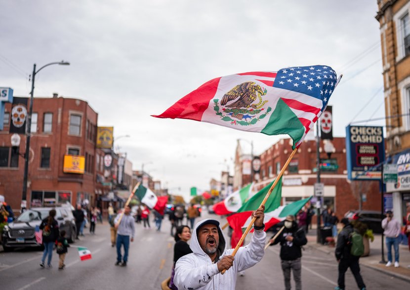 Protestujący macha flagą z fragmentem flagi narodowej Meksyku i flagi Stanów Zjednoczonych w dzielnicy Little Village podczas protestu przeciwko Urzędowi Imigracyjnemu i Celnemu (ICE) po dwóch dniach nalotów na początku tygodnia w Chicago, Illinois, USA, 25 października 2025 r. Little Village to dzielnica w południowej części Chicago, zamieszkana przez liczną społeczność meksykańsko-amerykańską