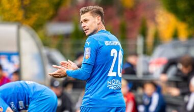 Piłkarz w niebieskiej koszulce z numerem 20 na plecach, patrzący w bok.