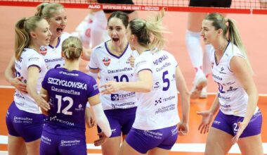 Siatkarki świętujące zwycięstwo na boisku siatkarskim.