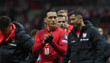 Piłkarze reprezentacji Polski w strojach meczowych, jeden z nich klaszcze.