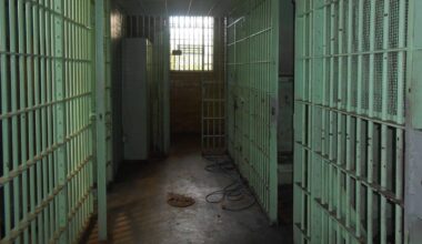 Korytarz więzienny z celami po obu stronach, z oknem na końcu korytarza.