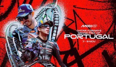 Dwóch motocyklistów w strojach wyścigowych na tle grafiki promującej Grand Prix Portugalii MotoGP