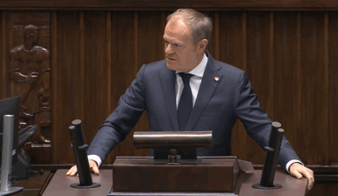 Donald Tusk, premier Polski, przemawia za mównicą w sali sejmowej.