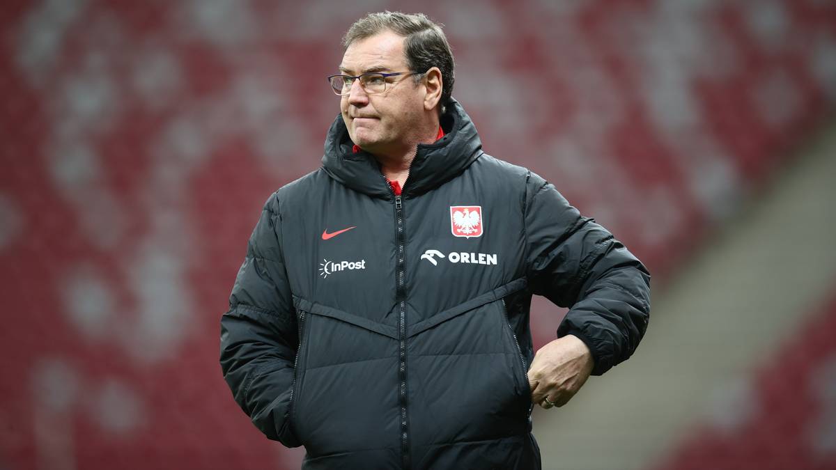 Michał Probierz, selekcjoner reprezentacji Polski, w kurtce z logo "ORLEN", stoi na tle stadionu.