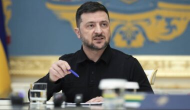 Wołodymyr Zełenski, prezydent Ukrainy, siedzi przy stole i gestykuluje piórem podczas rozmowy lub wywiadu.