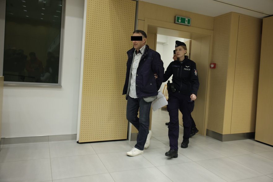 Oskarżony Adam R. wprowadzany na salę rozpraw w poznańskim sądzie