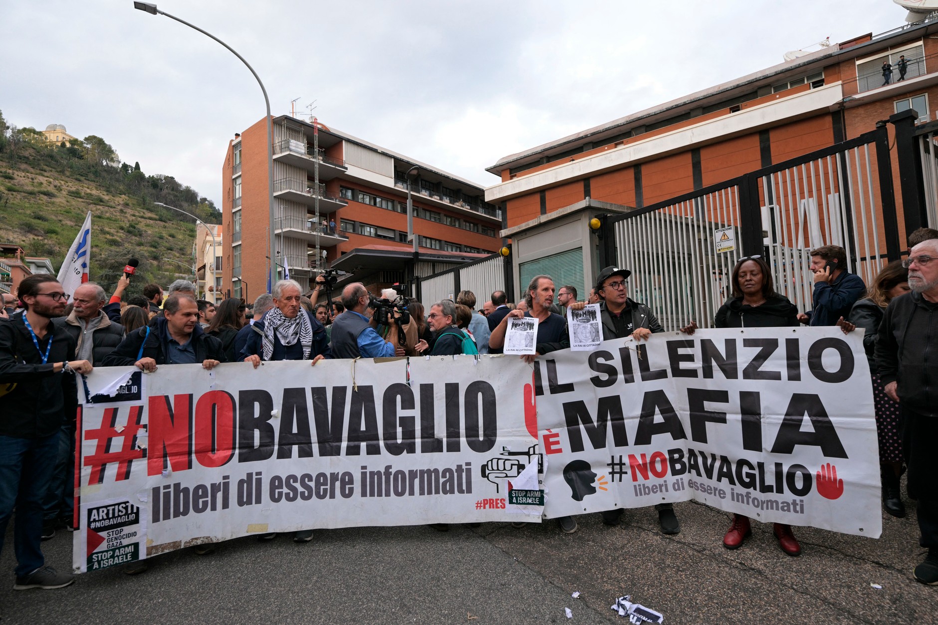 Ludzie z transparentami z napisami "Milczenie to mafia" oraz "Bez knebla – wolność do bycia informowanym" przed siedzibą włoskiego nadawcy telewizyjnego RAI w Rzymie, okazując wsparcie włoskiemu dziennikarzowi Sigfridowi Ranucciemu (17 października 2025 r.)
