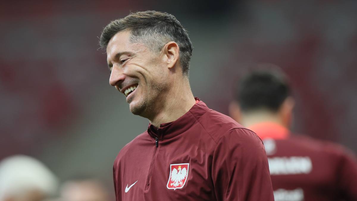 Robert Lewandowski w stroju treningowym reprezentacji Polski, uśmiecha się podczas treningu.