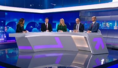 Cztery osoby siedzą przy stole w studiu telewizyjnym podczas debaty.