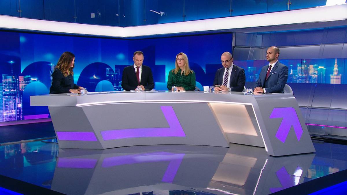 Cztery osoby siedzą przy stole w studiu telewizyjnym podczas debaty.