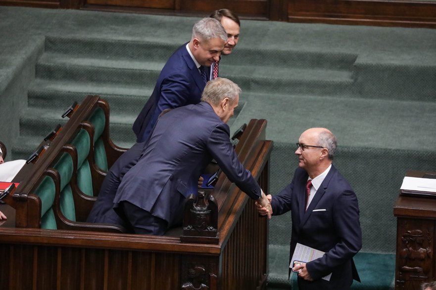 Premier Donald Tusk (plecami) gratuje Włodzimierzowi Czarzastemu wyboru na marszałka — Warszawa, 18.11.2025 r.