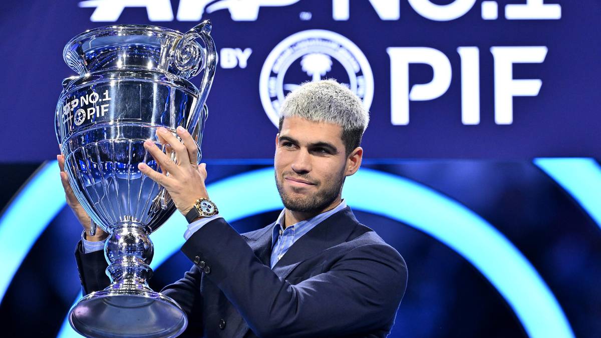 Mężczyzna w garniturze trzyma puchar ATP Finals.