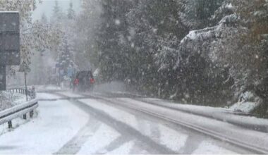 Droga pokryta śniegiem, po której porusza się samochód w trakcie opadów śniegu.