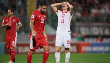 Piłkarz reprezentacji Polski z numerem 13 na koszulce, trzymający się za głowę w geście rozpaczy.