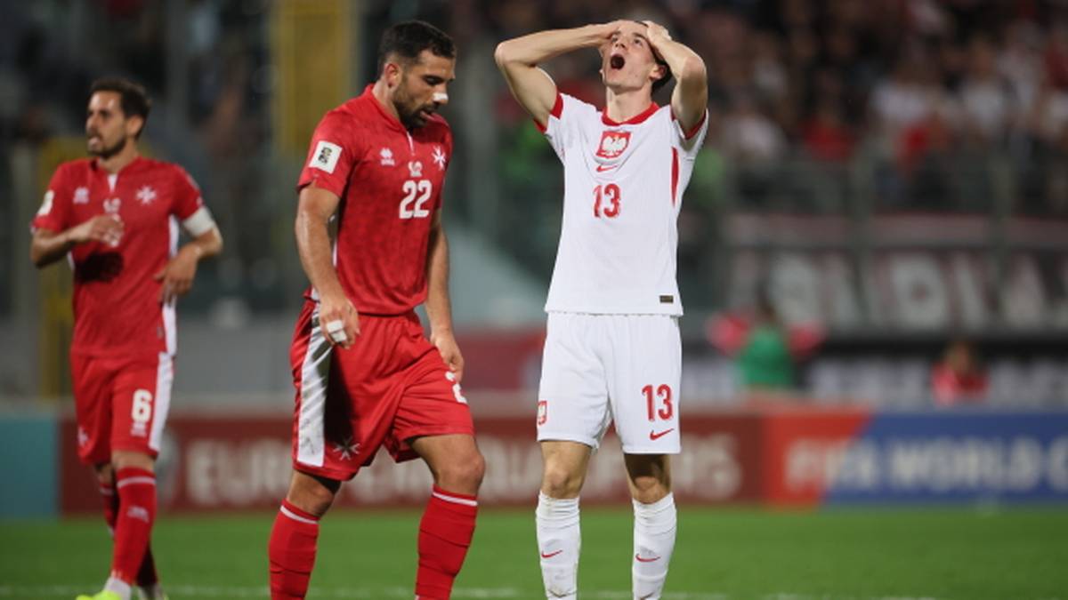 Piłkarz reprezentacji Polski z numerem 13 na koszulce, trzymający się za głowę w geście rozpaczy.