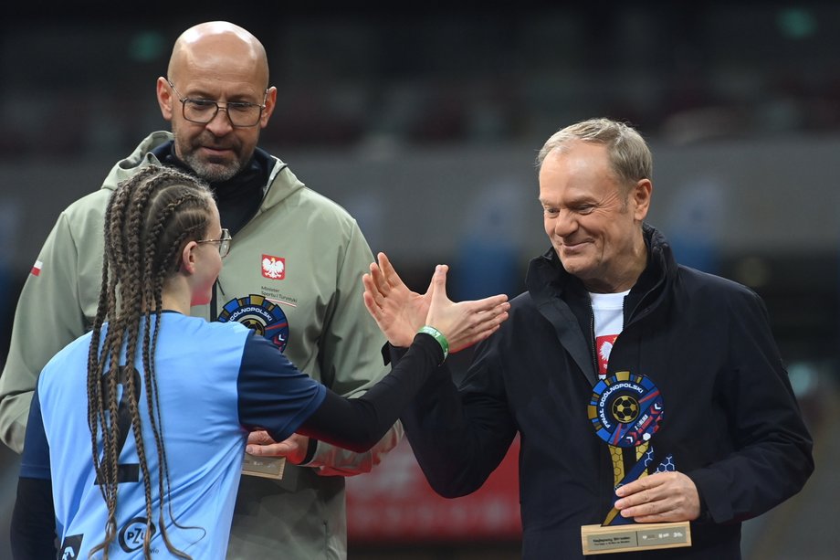 Premier Donald Tusk (P) oraz minister sportu i turystyki Jakub Rutnicki (L-tył) podczas finału akcji "Z Orlika na Stadion" w Warszawie. 