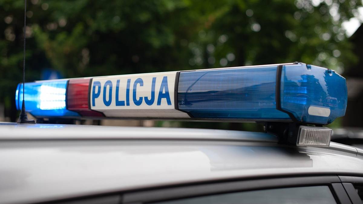 Niebieska belka świetlna z napisem POLICJA na dachu radiowozu.