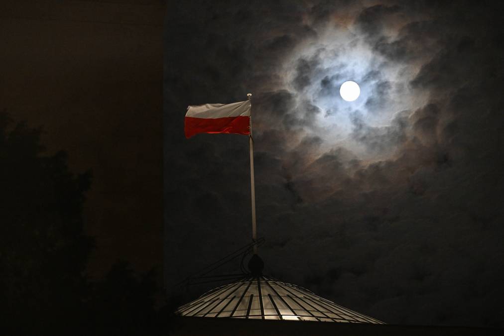 Superpełnia Księżyca nad nocnym niebem w Przemyślu z polską flagą