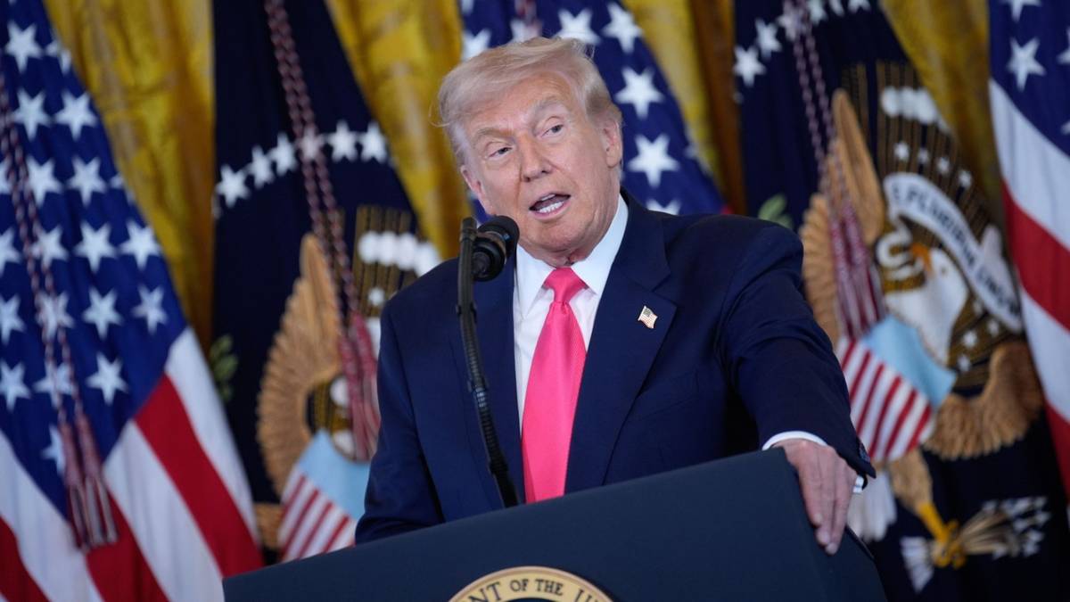 Donald Trump przemawia za mównicą na tle amerykańskich flag.