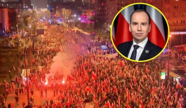 Tłum ludzi z flagami i racami na ulicy, z wizerunkiem Karola Nawrockiego w prawym górnym rogu.