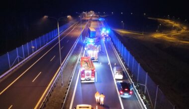 Nocny widok na drogę ekspresową S3 z widocznymi pojazdami służb ratowniczych i uszkodzoną ciężarówką na pasie drogowym.