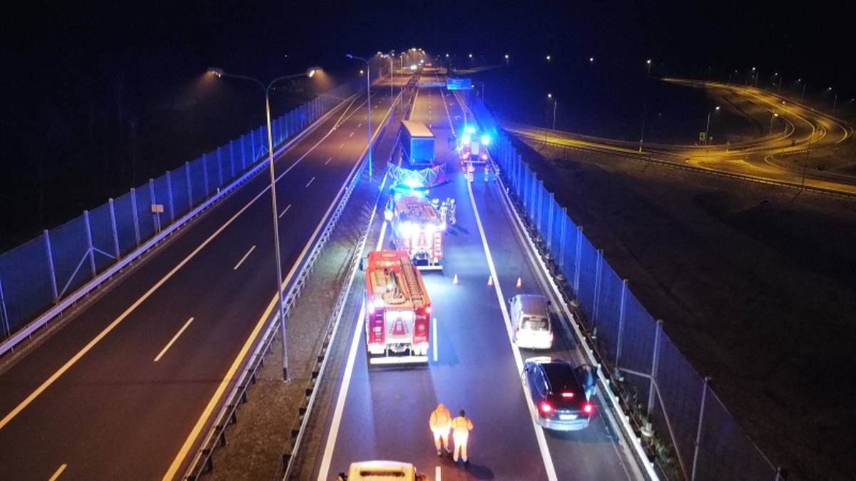 Nocny widok na drogę ekspresową S3 z widocznymi pojazdami służb ratowniczych i uszkodzoną ciężarówką na pasie drogowym.