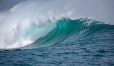Potężna fala oceaniczna z grzywą w kolorze turkusowym, na tle burzowych chmur.