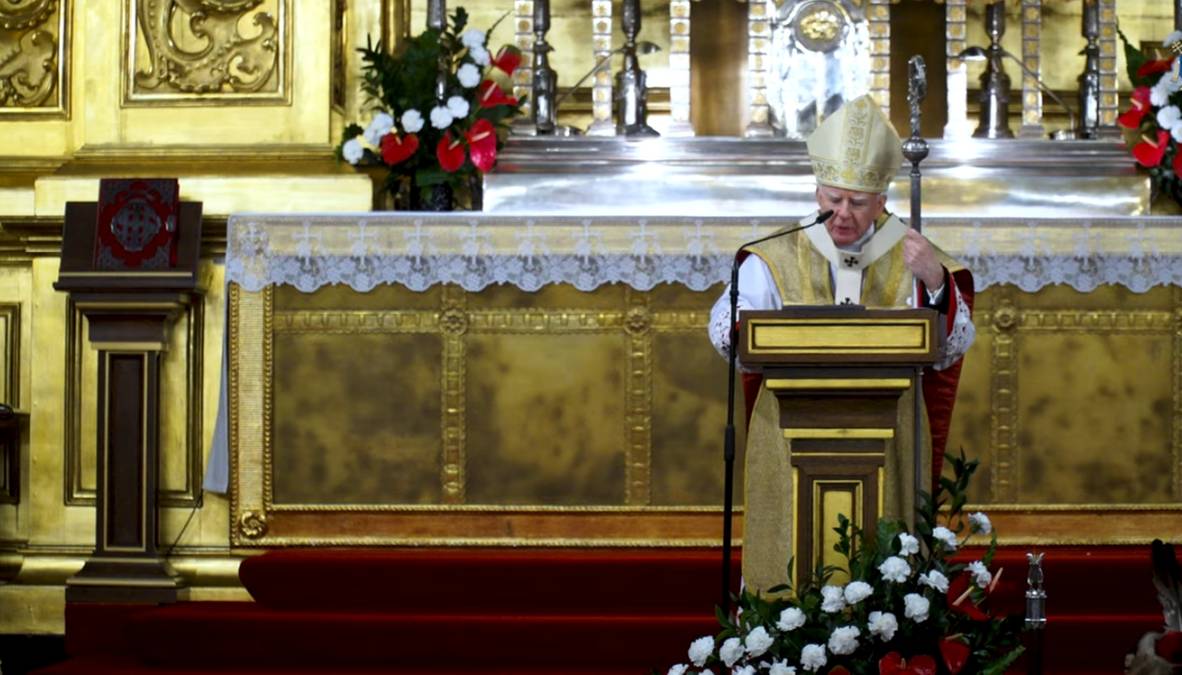 Arcybiskup Marek Jędraszewski w szatach liturgicznych stoi za mównicą w katedrze na Wawelu podczas mszy świętej.