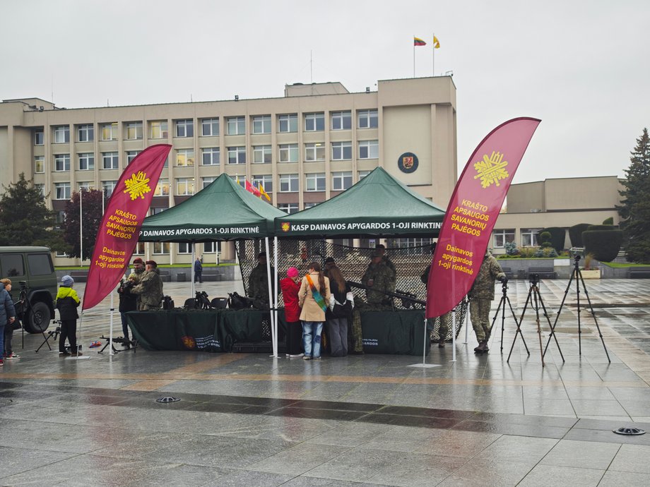 Litewski odpowiednich naszych "Terytorialsów" pokazuje broń i zachęca do służby