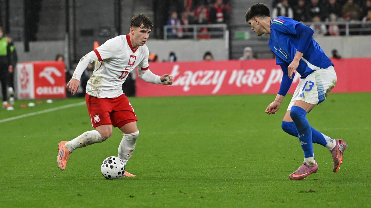 Dwóch piłkarzy podczas meczu piłki nożnej, jeden w stroju Polski, drugi w stroju Włoch, walczy o piłkę.