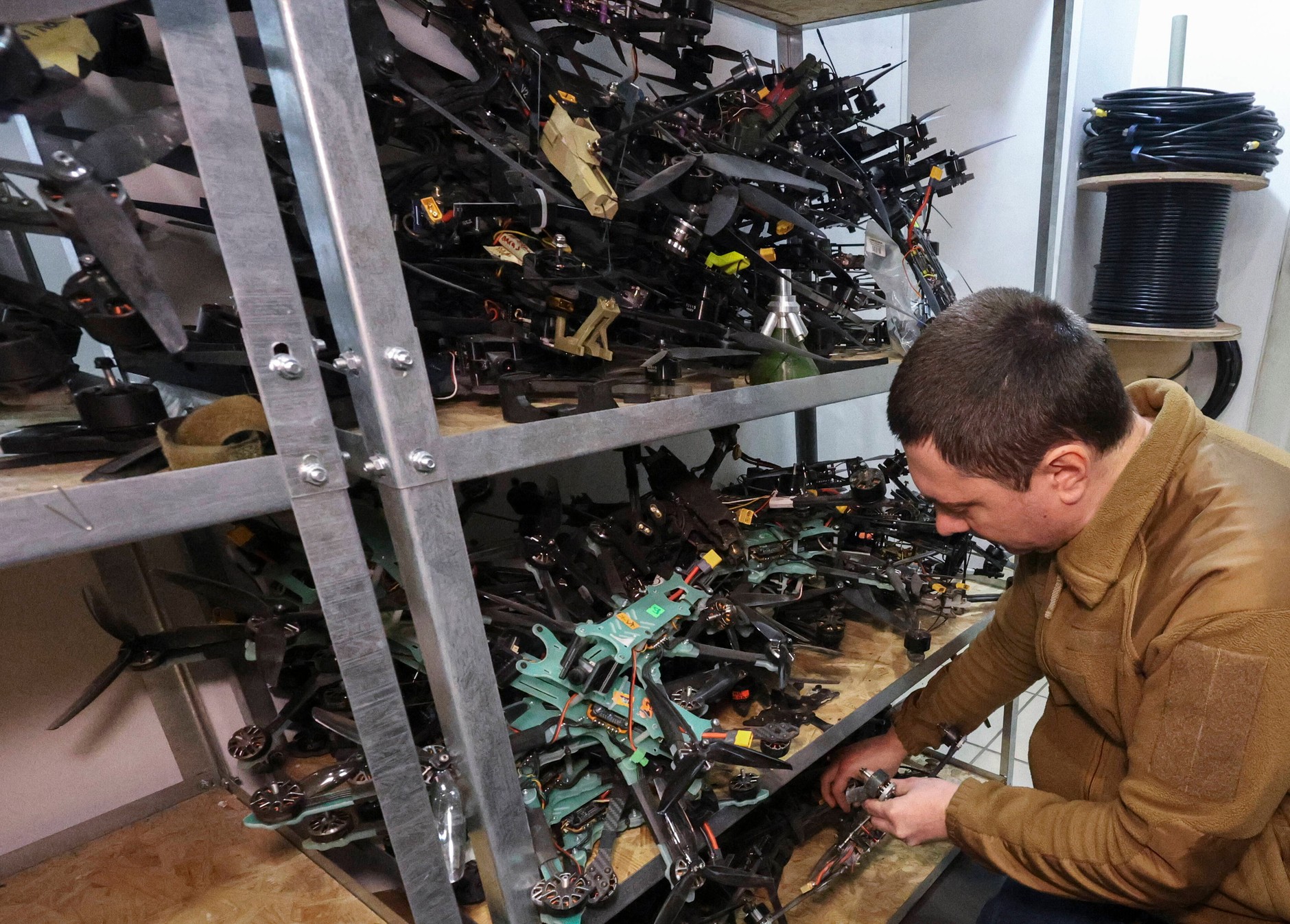 Ukraiński żołnierz naprawiający drony w nieujawnionej lokalizacji w obwodzie charkowskim, Ukraina, 17 listopada 2025 r.