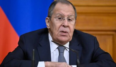 Siergiej Ławrow, minister spraw zagranicznych Rosji, siedzi przy stole, mówi do mikrofonu.