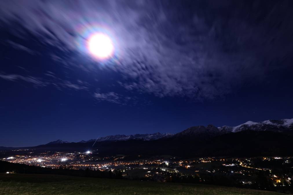 Superpełnia Księżyca widoczna nad nocnym miastem