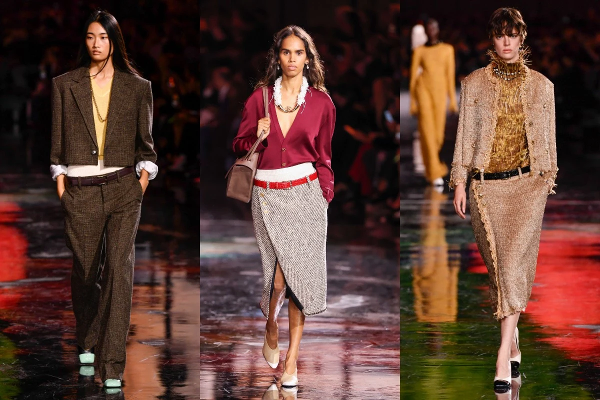 Trendy CHANEL wiosna/lato 2026 Trzy modele prezentują eleganckie stylizacje na wybiegu podczas pokazu mody, ubrani w stroje biznesowe oraz kreacje z tweedu i dzianiny, na tle błyszczącej, kolorowej sceny.