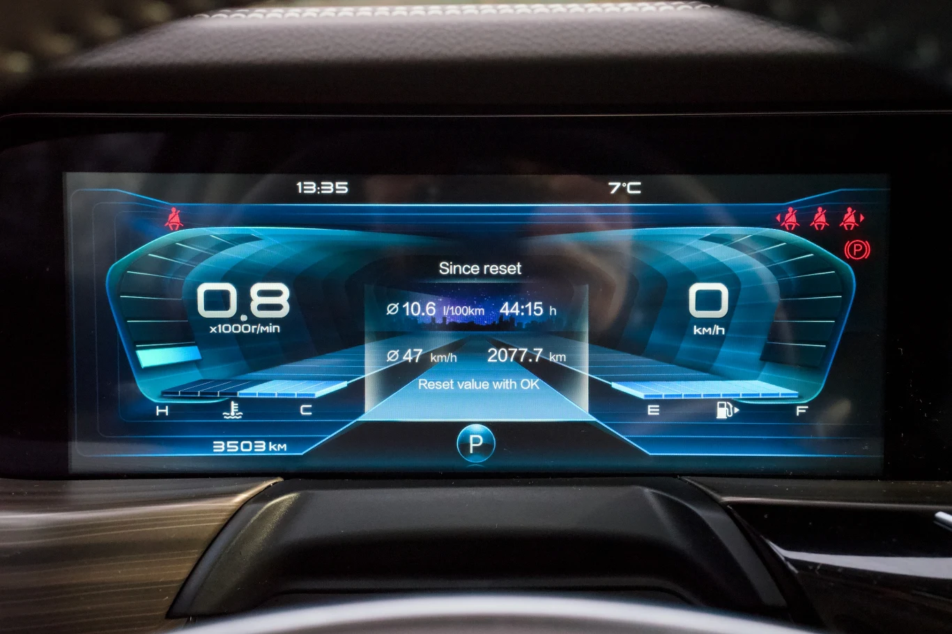 Cyfrowy kokpit samochodowy z wyświetlaczem liczników, prędkościomierza i obrotomierza wraz z informacjami o przebiegu, zużyciu paliwa oraz temperaturze na zewnątrz.