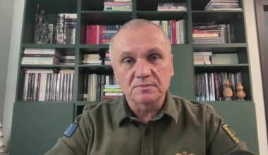 Generał Roman Polko siedzi przed regałem z książkami, ubrany w mundur.