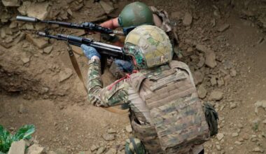 Dw&oacute;ch żołnierzy w kamizelkach taktycznych i hełmach celuje z broni.